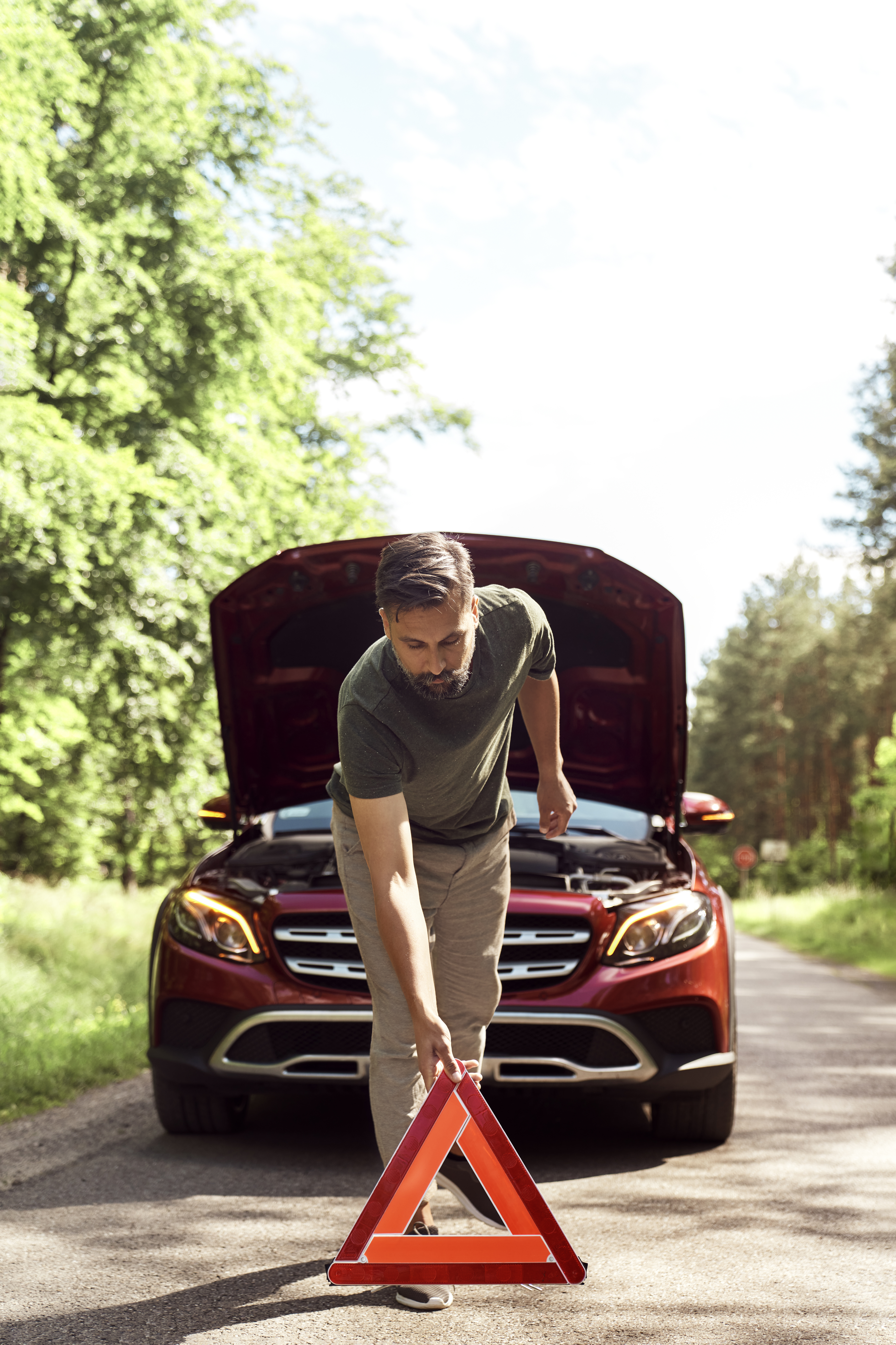 Front view of man placing red warning triangle